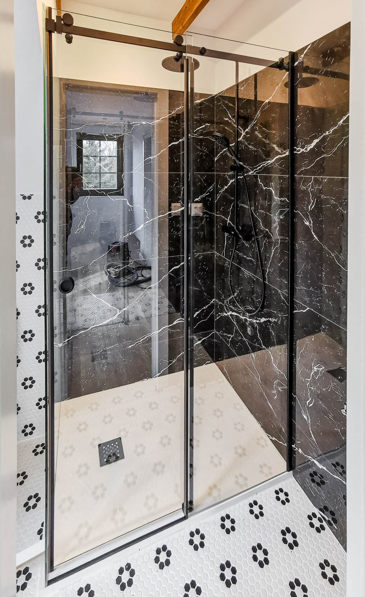 Posuvná sprcha s čiernym kovaním perfektne ladí s veľko-formátovým obkladom